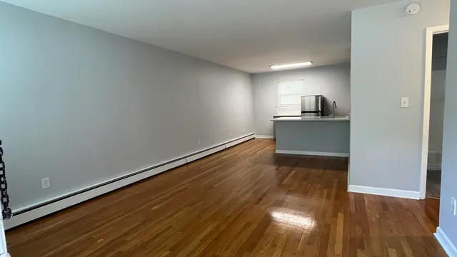 a view of a kitchen with wooden floor and electronic appliances