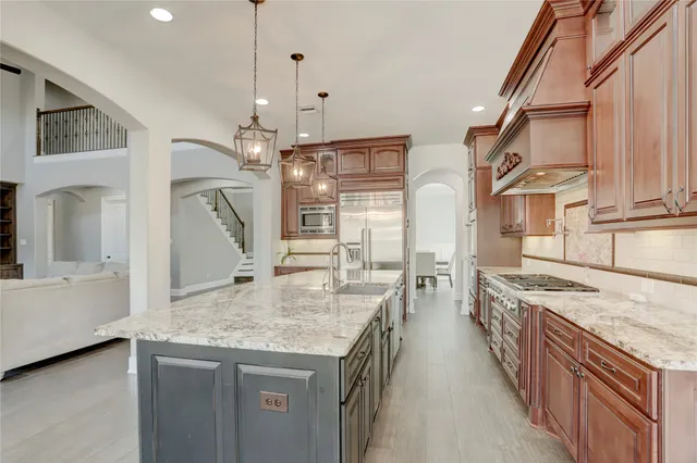 a kitchen with stainless steel appliances granite countertop a sink stove and refrigerator