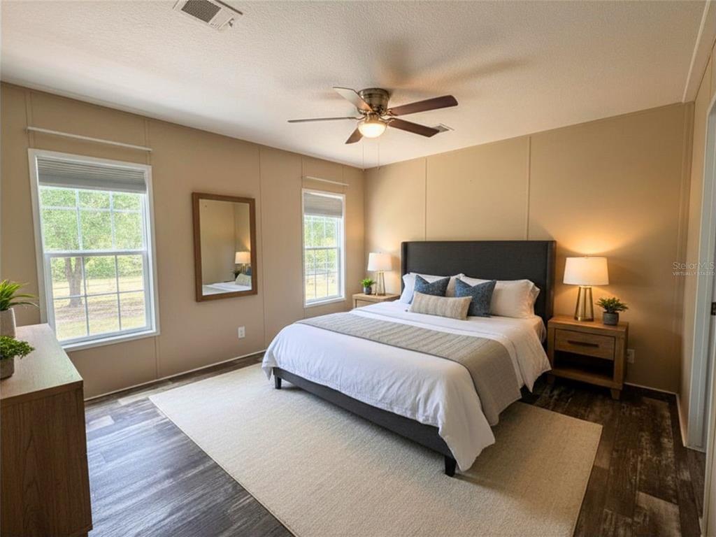 9827 Southeast Hoth Road Arcadia, FL 34266 - Photo 19 of 28 a bedroom with a large bed chandelier and a window