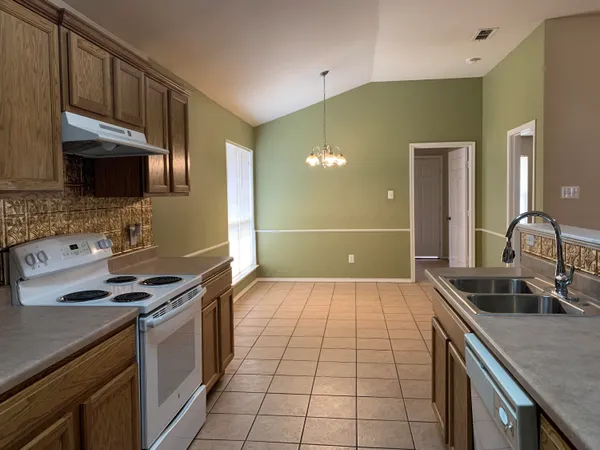 a kitchen with a sink a stove and cabinets