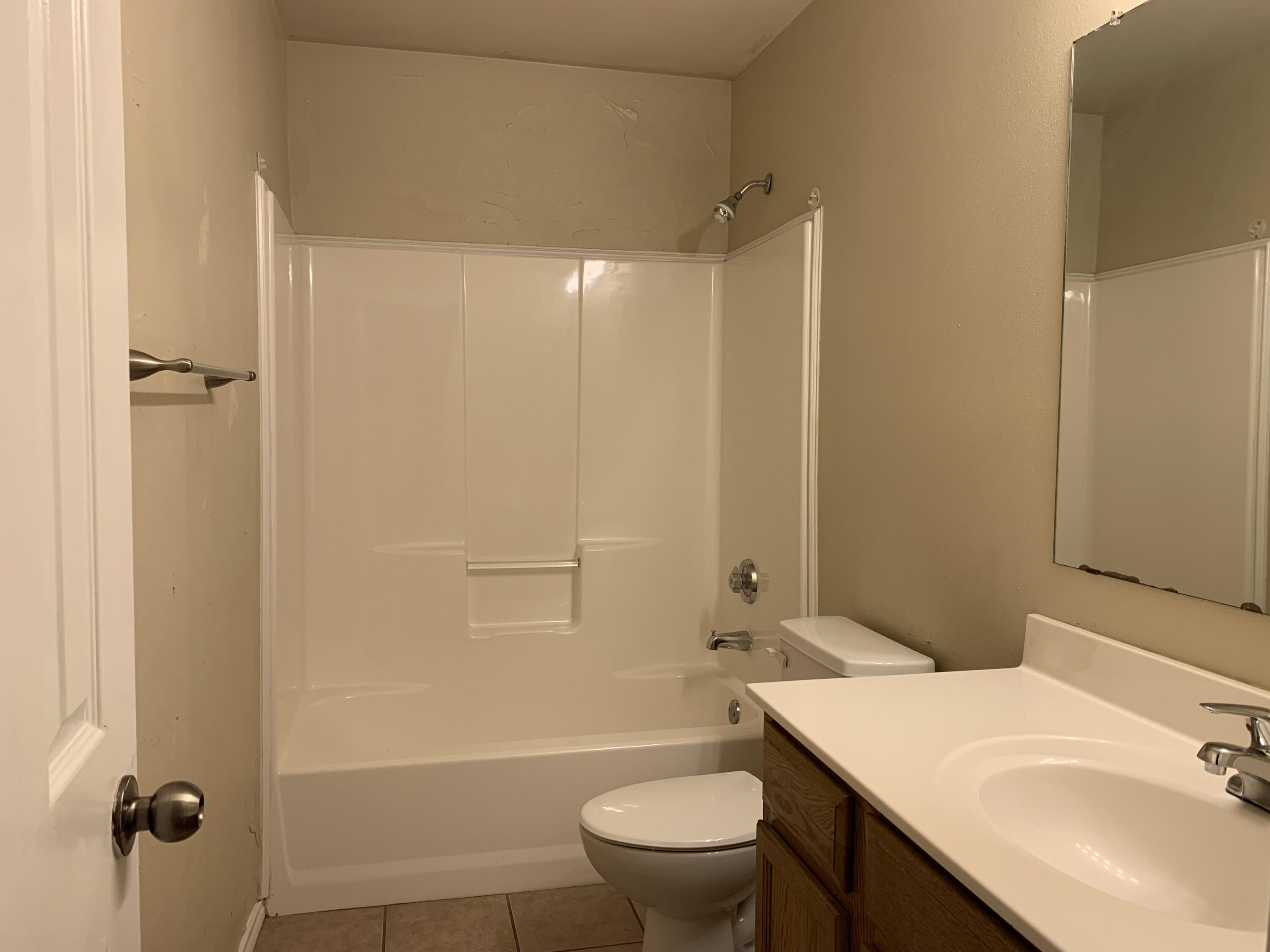 6717 89th Street Lubbock, TX 79424 - Photo 5 of 10 a bathroom with a sink a toilet and shower
