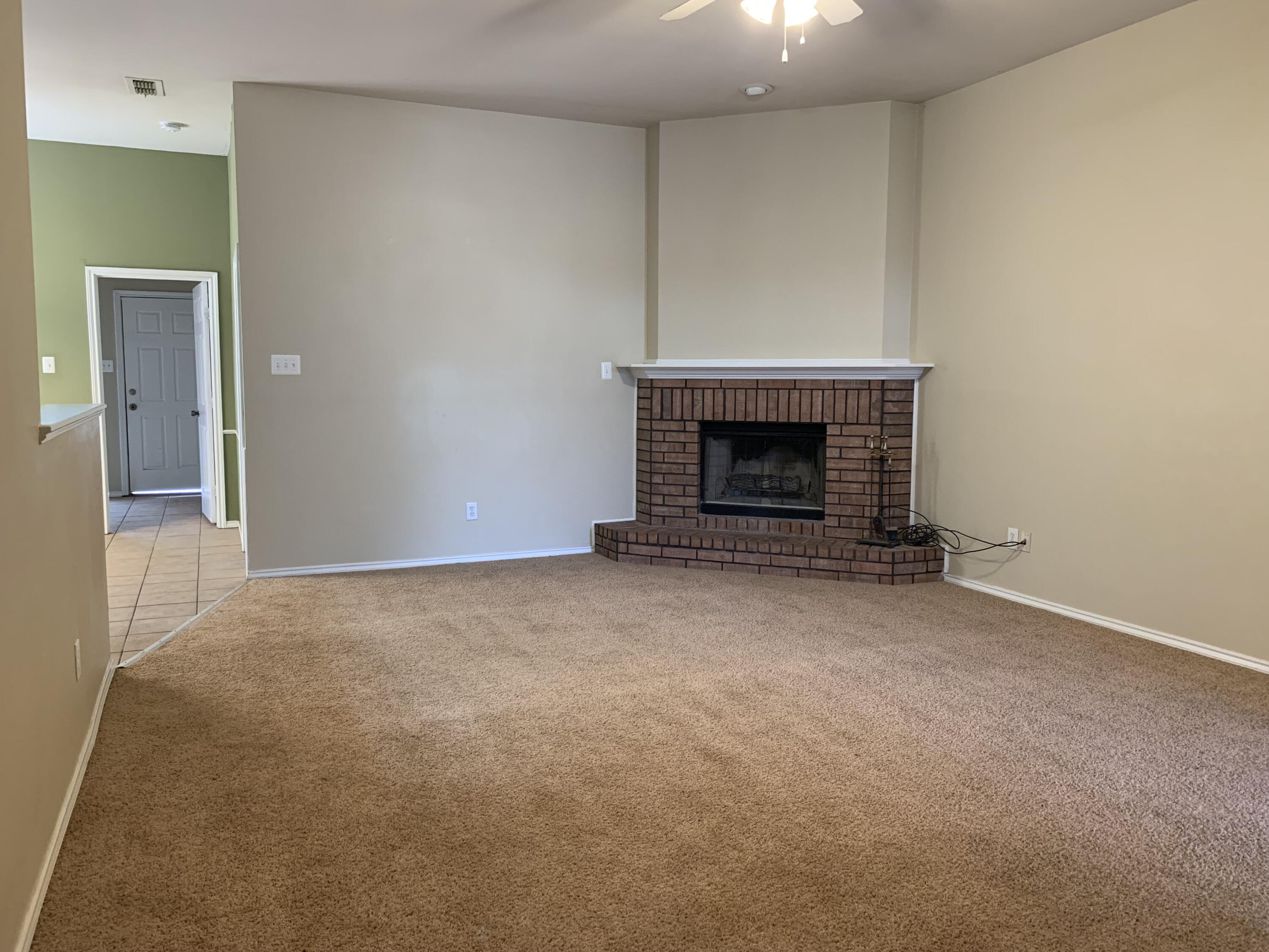 6717 89th Street Lubbock, TX 79424 - Photo 9 of 10 an empty room with a fireplace