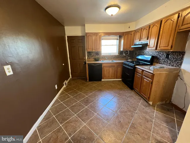 a kitchen with granite countertop a sink cabinets and stainless steel appliances