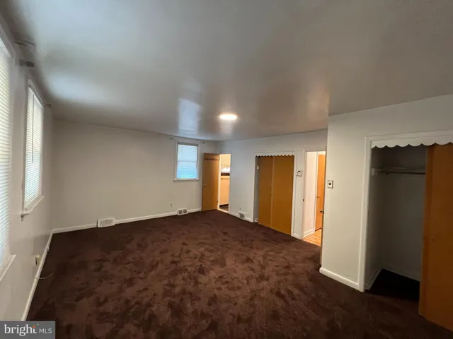 an empty room with closet and wooden floor