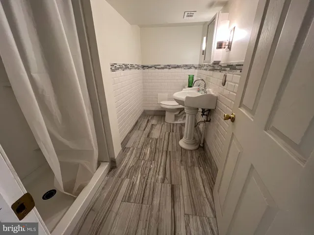 a view of a hallway with wooden floor and bench