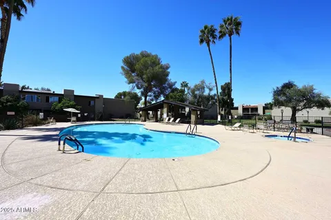 a view of a swimming pool with a lounge chair and palm trees