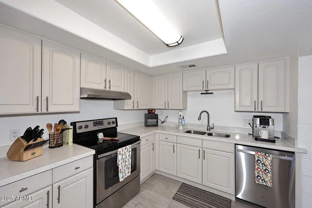 a kitchen with cabinets appliances a sink and a counter top space