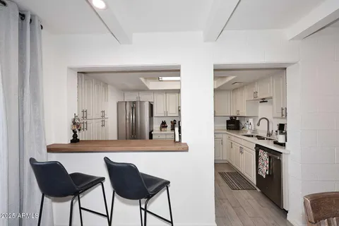 a kitchen with kitchen island a counter top space a sink stainless steel appliances and cabinets