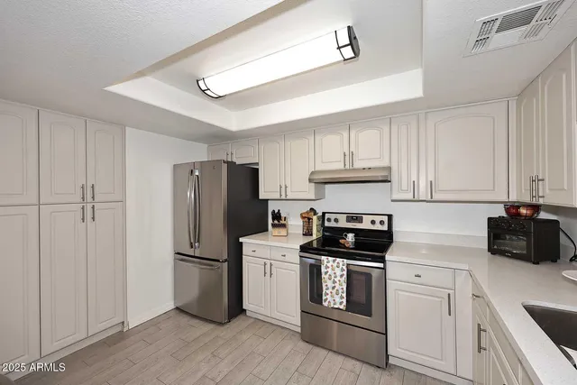 a kitchen with a refrigerator stove and white cabinets