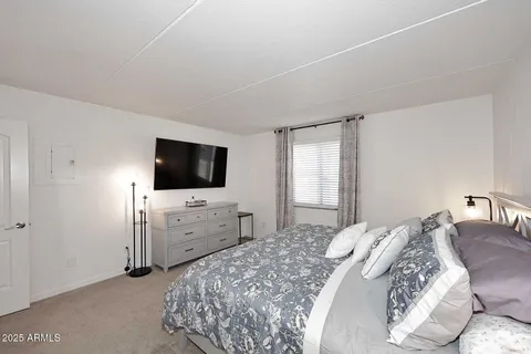 a bedroom with a bed and a flat screen tv