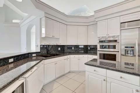 a kitchen with granite countertop a sink a stove and cabinets