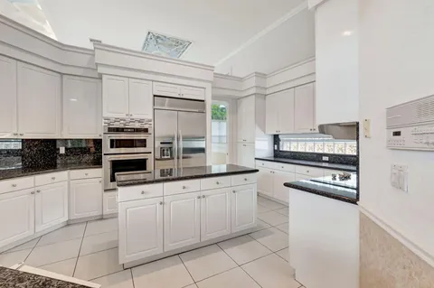 a kitchen with white cabinets and appliances