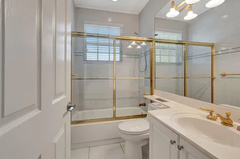 a bathroom with a shower a sink and toilet