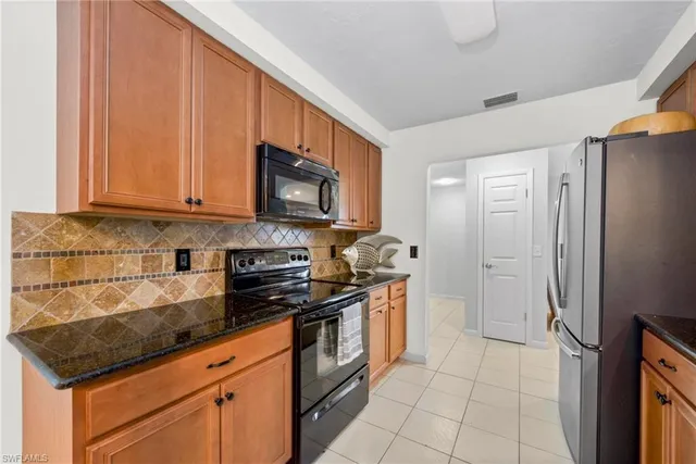 a kitchen with stainless steel appliances granite countertop a refrigerator and a stove top oven