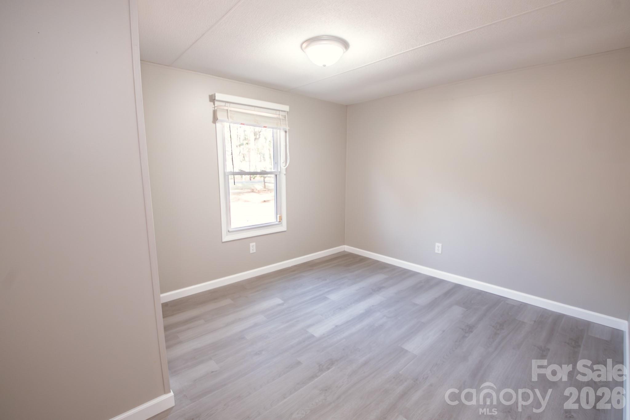 44082 Harper Hearne Road New London, NC 28127 - Photo 20 of 38 an empty room with wooden floor and windows