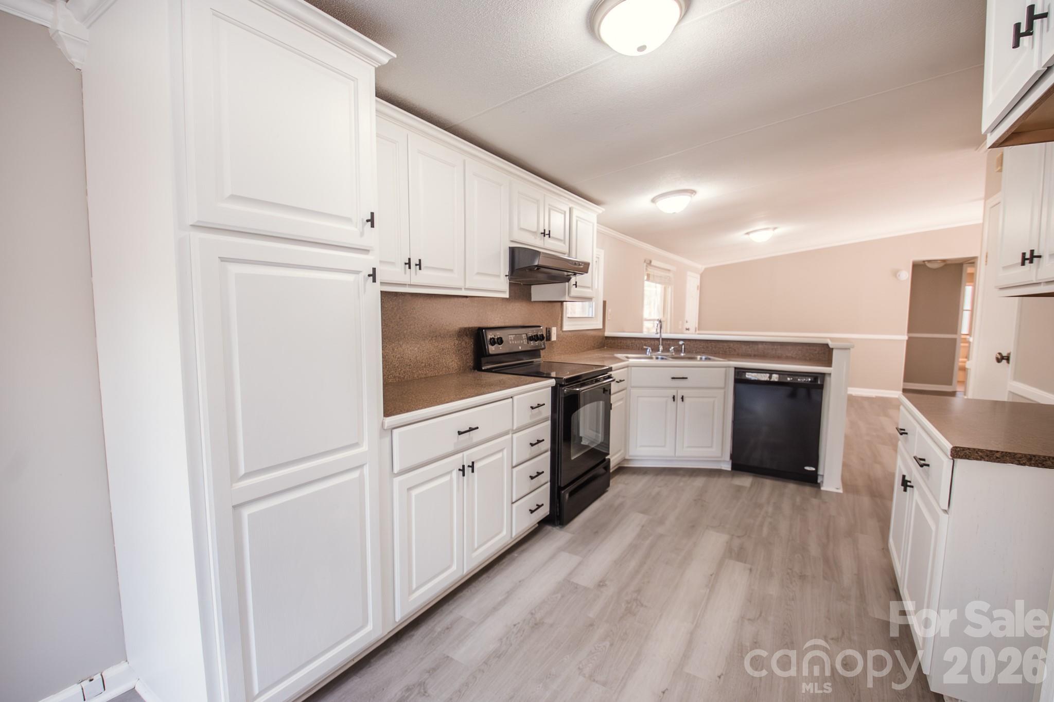 44082 Harper Hearne Road New London, NC 28127 - Photo 2 of 38 a kitchen with granite countertop white cabinets and white appliances
