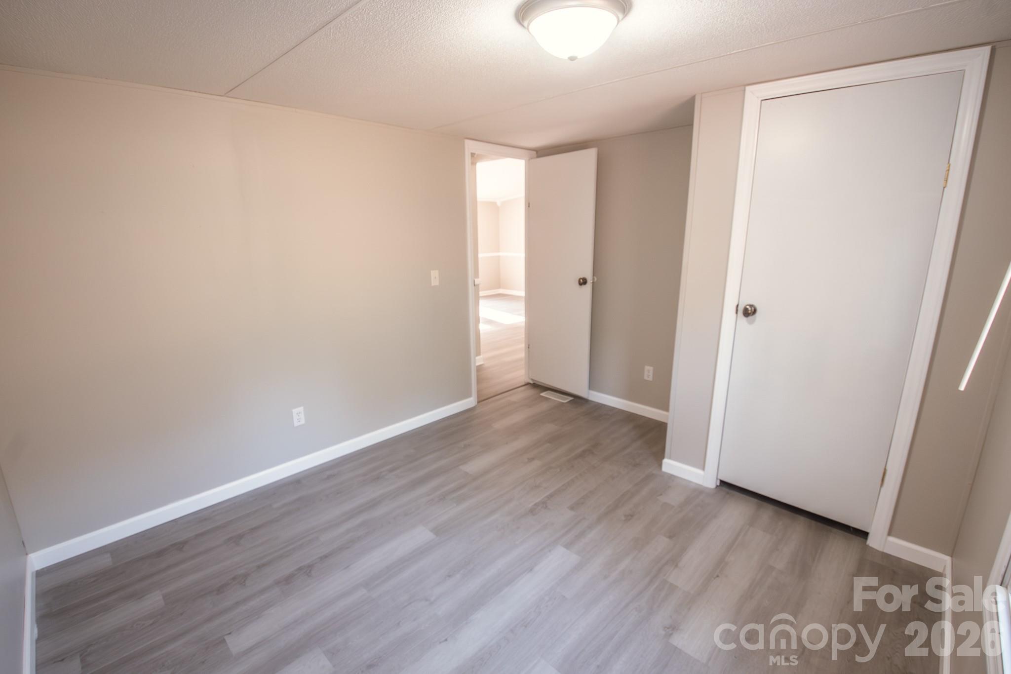 44082 Harper Hearne Road New London, NC 28127 - Photo 21 of 38 a view of an empty room with wooden floor