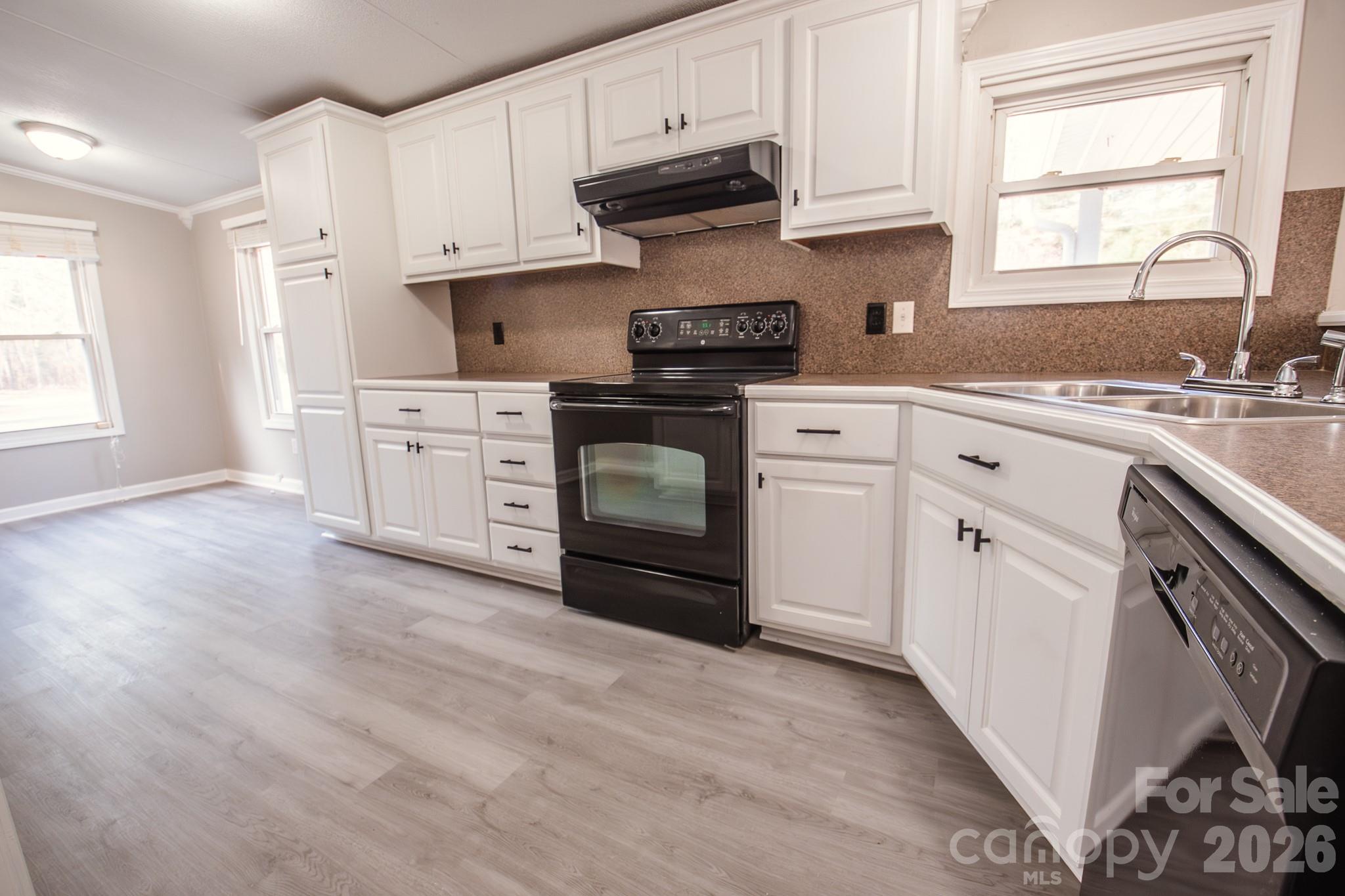 44082 Harper Hearne Road New London, NC 28127 - Photo 3 of 38 a kitchen with granite countertop white cabinets and white appliances