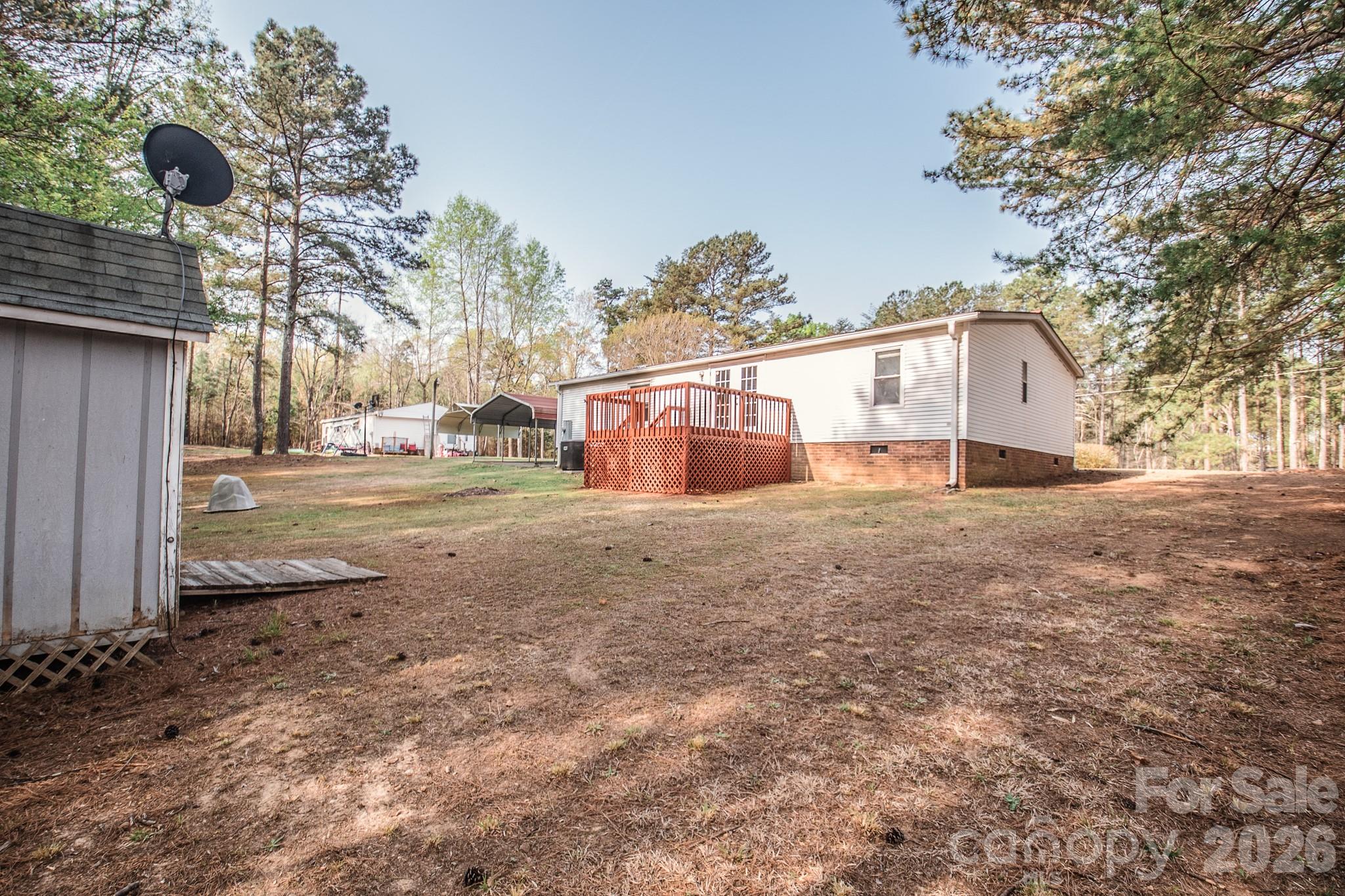 44082 Harper Hearne Road New London, NC 28127 - Photo 35 of 38 a backyard of a house with large trees and outdoor seating