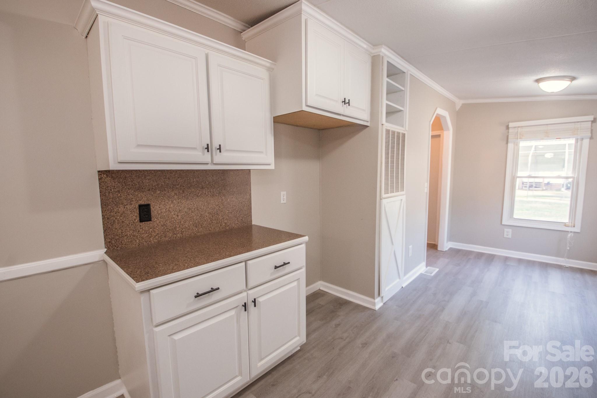 44082 Harper Hearne Road New London, NC 28127 - Photo 7 of 38 a kitchen with white cabinets and a wooden floor