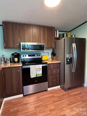 a kitchen with stainless steel appliances granite countertop a refrigerator and a stove top oven