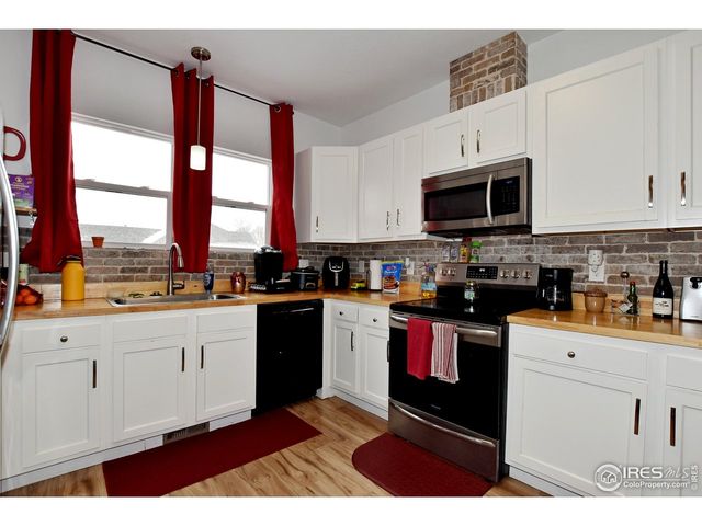 a kitchen with stainless steel appliances granite countertop a stove a sink and white cabinets