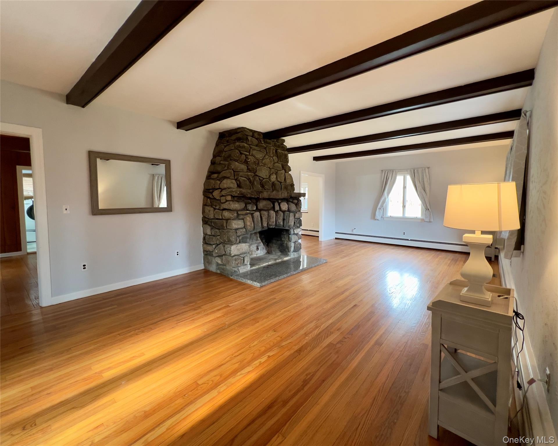 85 Washington Road Carmel, NY 10512 - Photo 7 of 30 a view of a livingroom with wooden floor a fireplace and a window