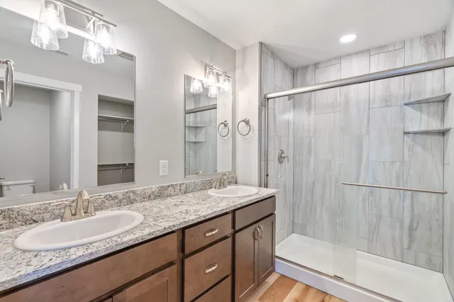 a bathroom with a granite countertop sink shower and a mirror