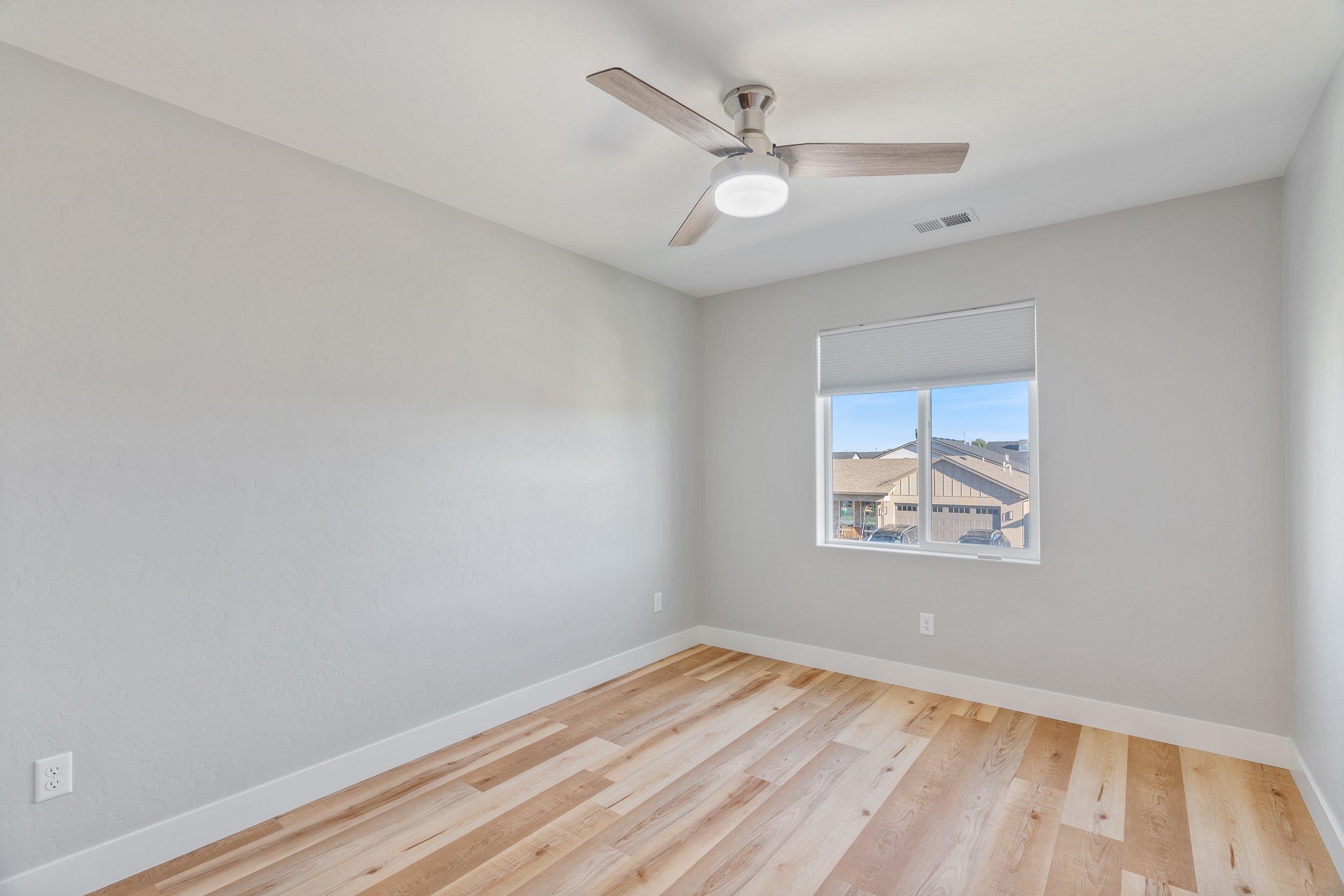 2453 Ross Road, Unit A Grand Junction, CO 81505 - Photo 17 of 27 an empty room with wooden floor and ceiling fan