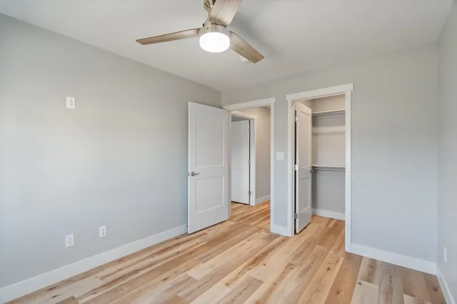 a view of room with wooden floor and ceiling fan