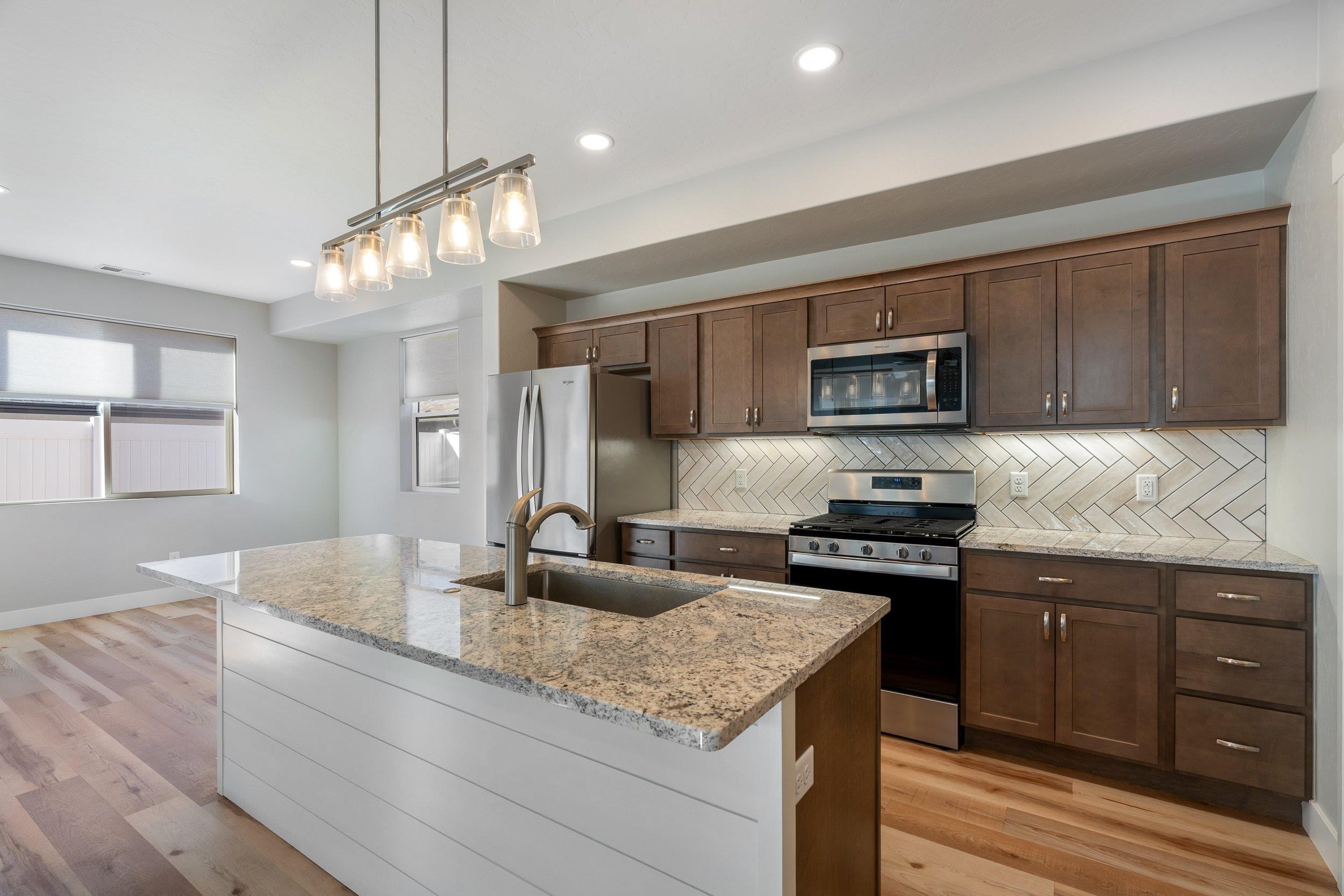 2453 Ross Road, Unit A Grand Junction, CO 81505 - Photo 6 of 27 a kitchen with stainless steel appliances granite countertop a sink stove and refrigerator