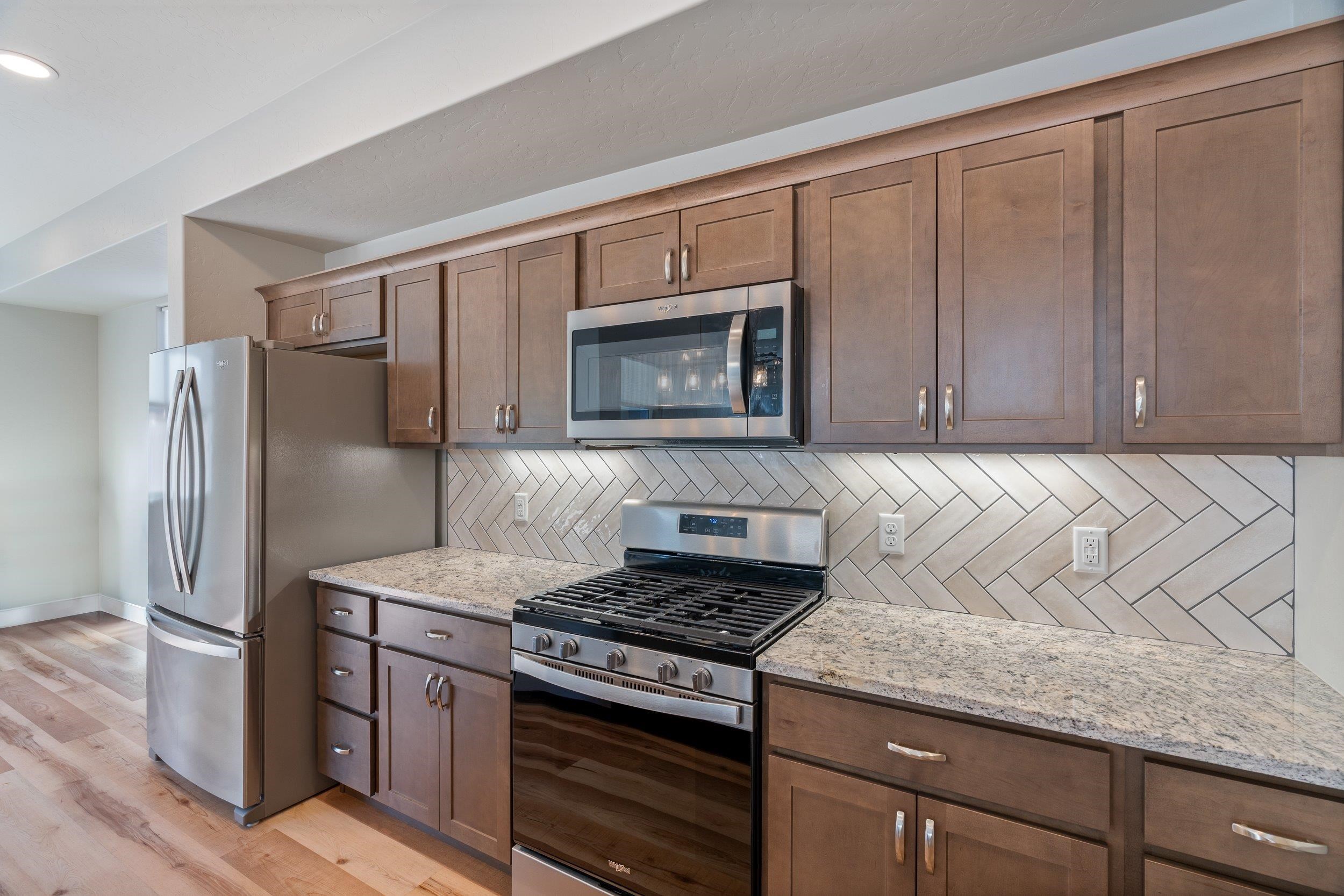 2453 Ross Road, Unit A Grand Junction, CO 81505 - Photo 7 of 27 a kitchen with stainless steel appliances granite countertop a refrigerator stove and sink