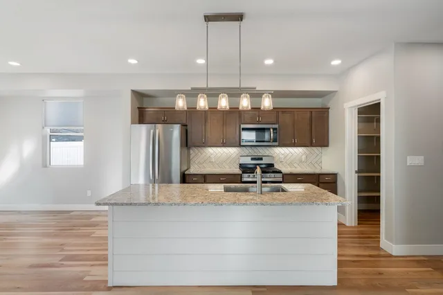 a kitchen with kitchen island a counter top space a sink and appliances