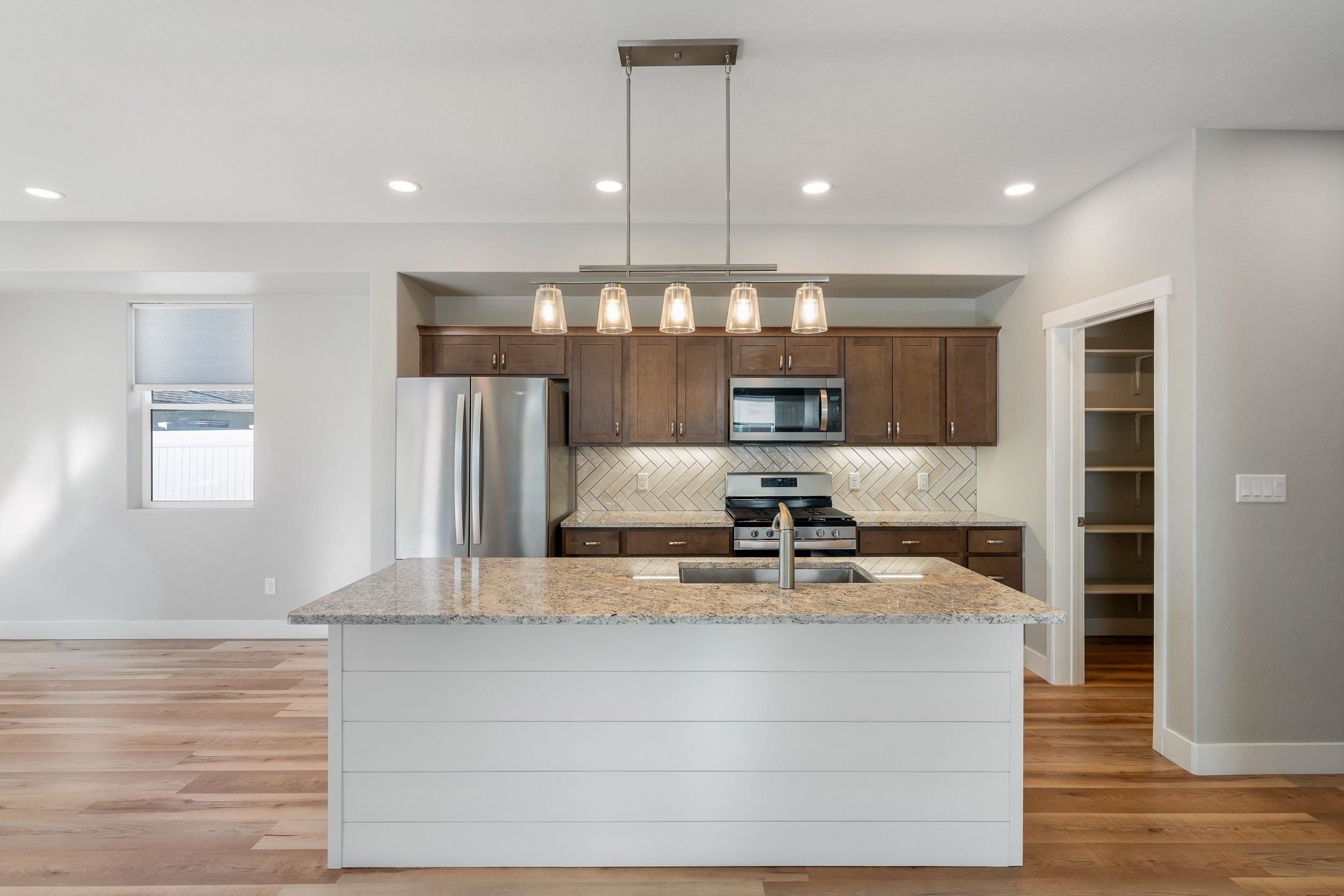 2453 Ross Road, Unit A Grand Junction, CO 81505 - Photo 8 of 27 a kitchen with kitchen island a counter top space a sink and appliances
