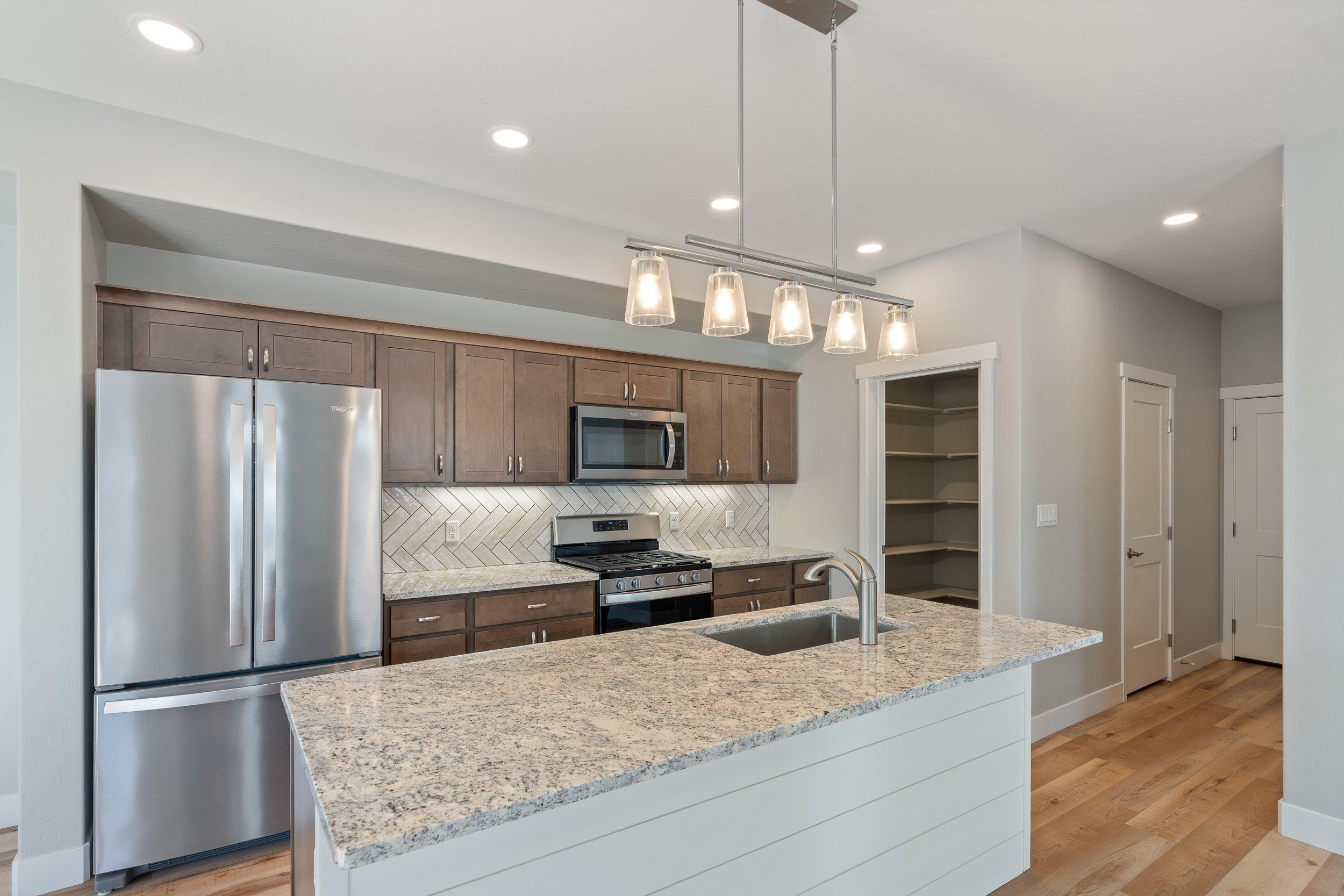 2453 Ross Road, Unit A Grand Junction, CO 81505 - Photo 9 of 27 a large kitchen with a refrigerator and a sink