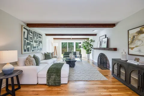 a living room with furniture fireplace and a large window