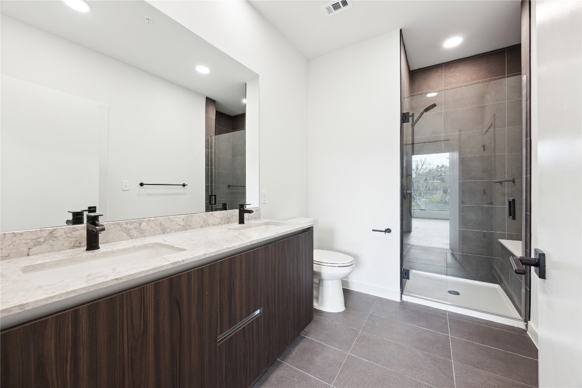 2209 South 1st Street, Unit 217 Austin, TX 78704 - Photo 4 of 29 a bathroom with a double vanity sink toilet and shower