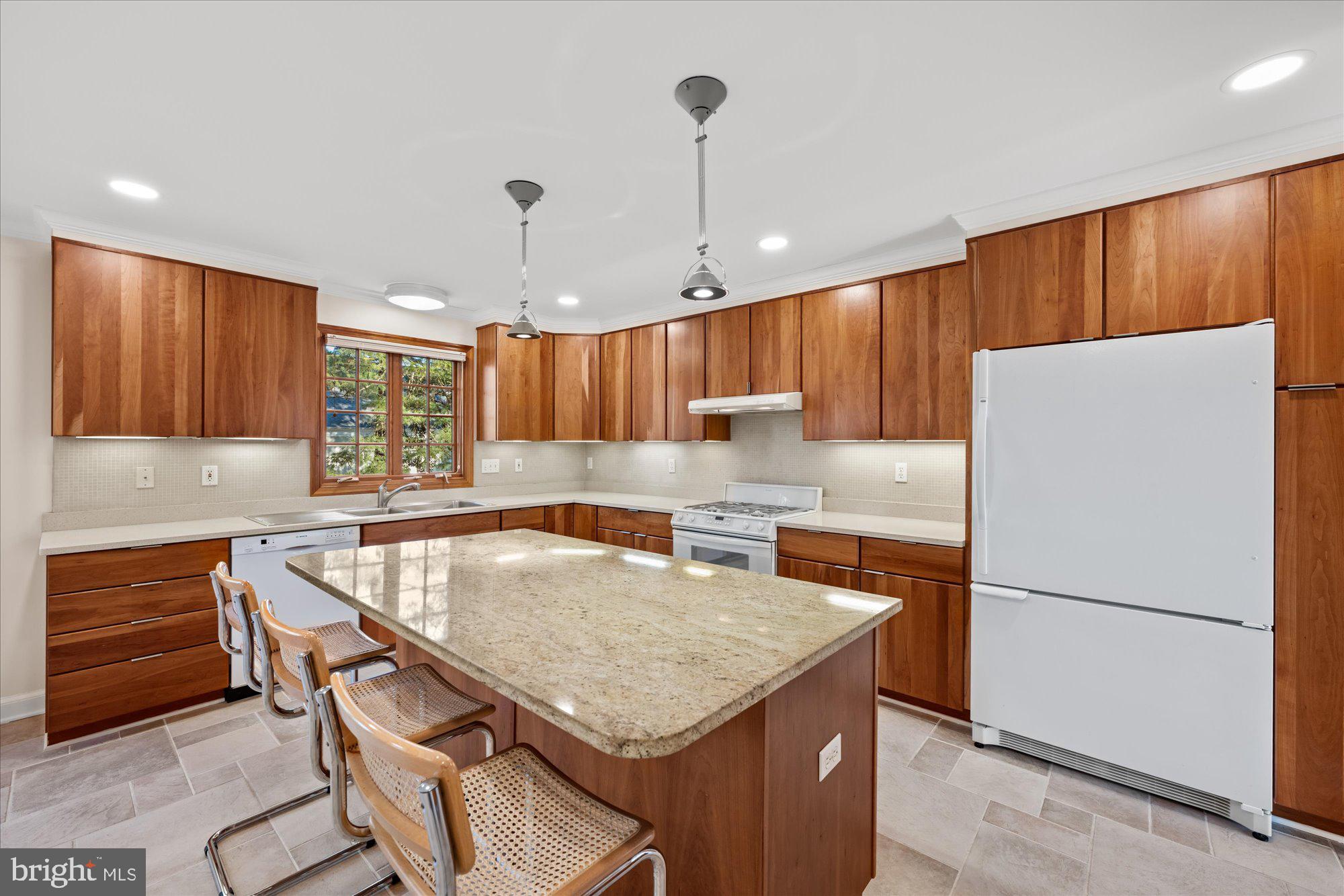 4238 50th Street Northwest Washington, DC 20016 - Photo 18 of 55 a kitchen with granite countertop a refrigerator a sink a stove a dining table and chairs