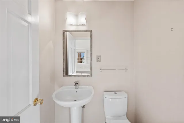 a bathroom with a toilet a sink and mirror