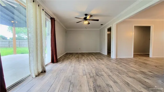 a view of a livingroom with wooden floor and a ceiling fan