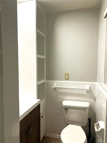 a bathroom with a toilet a sink and mirror