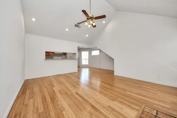 a view of a livingroom with a ceiling fan and wooden floor