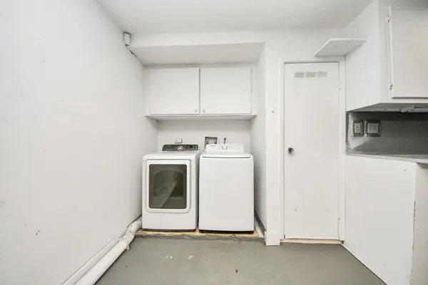 a utility room with cabinets washer and dryer