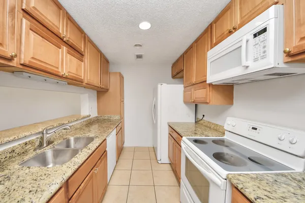 a kitchen with a sink stove top oven and cabinets