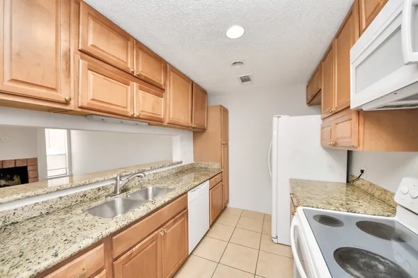 a kitchen with granite countertop stainless steel appliances granite countertop a sink and a stove