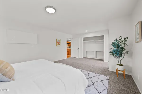 a bedroom with a large bed and a potted plant
