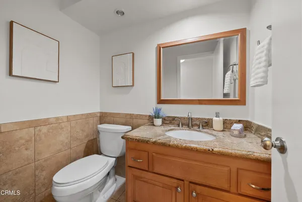 a bathroom with a granite countertop toilet sink and mirror