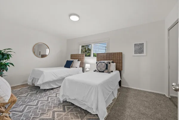 a bedroom with two beds and a potted plant