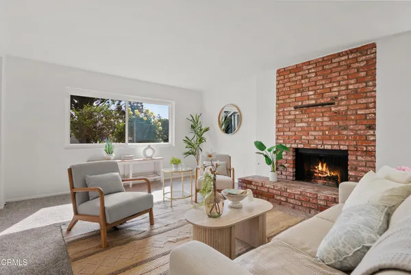 a living room with furniture a fireplace and a large window