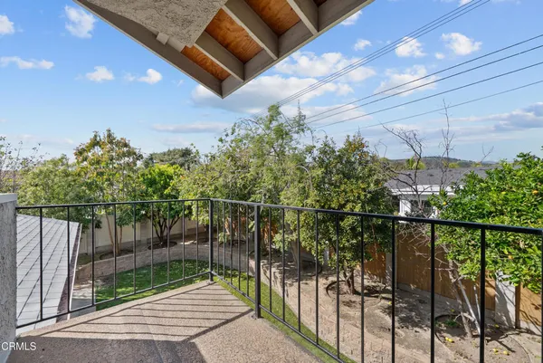 a roof deck with a dining table and chairs with wooden fence